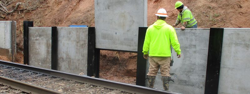 High Point Improvements - Workers place concrete panels for new retaining wall south of Wrenn Avenue